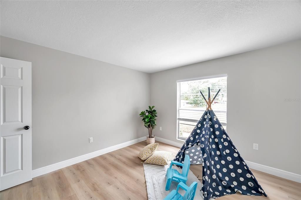 "Second bedroom showcasing ample space and natural light from the window overlooking the front yard—note: window to be replaced or credit given at closing.