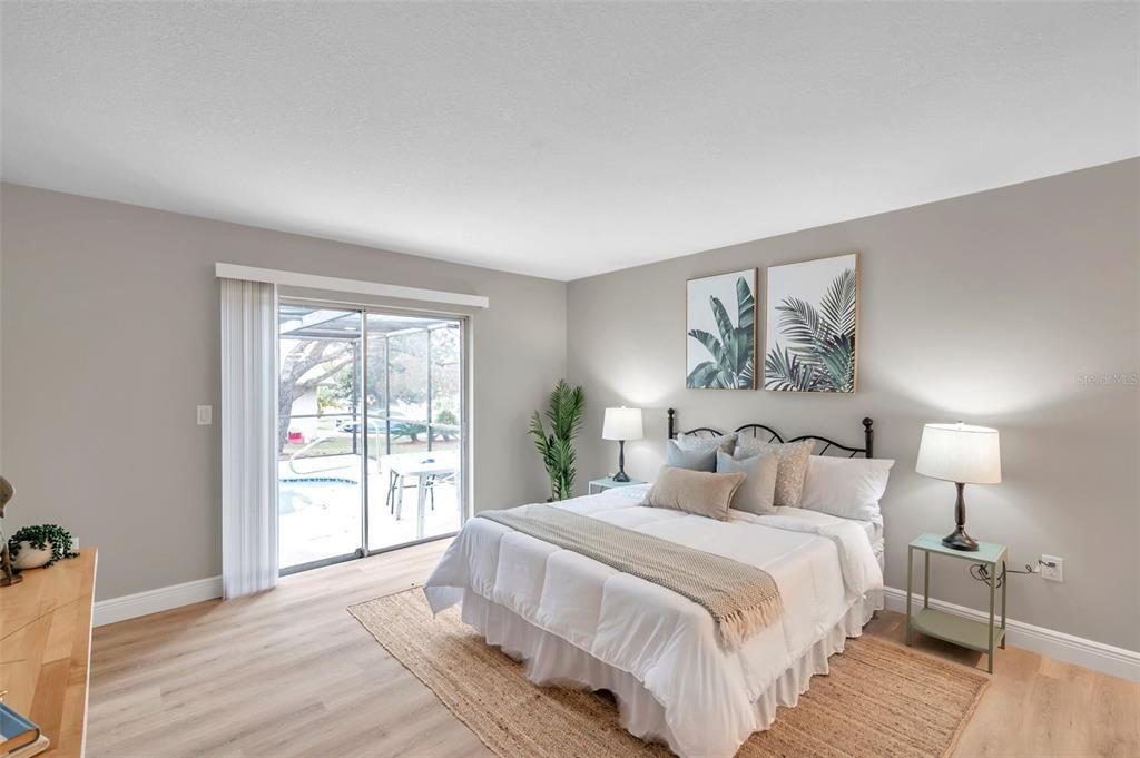 Spacious primary bedroom featuring sliding glass doors that open directly to the pool area—your private retreat with easy access to outdoor relaxation.