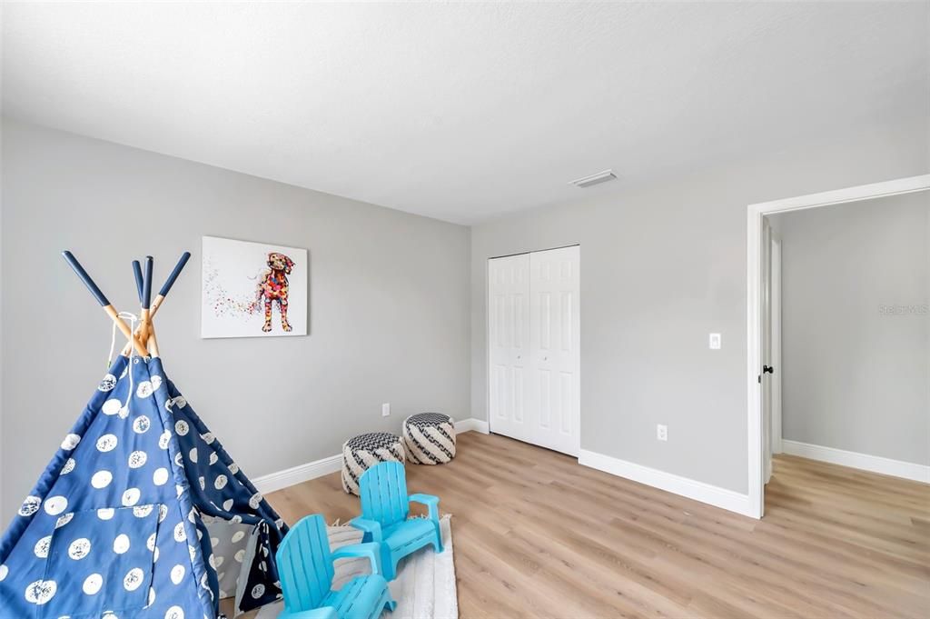 Well-lit second bedroom offering a front-facing window with serene yard views and endless possibilities as a craft room, man/woman cave, or second bedroom—window upgrade available with buyer credit.