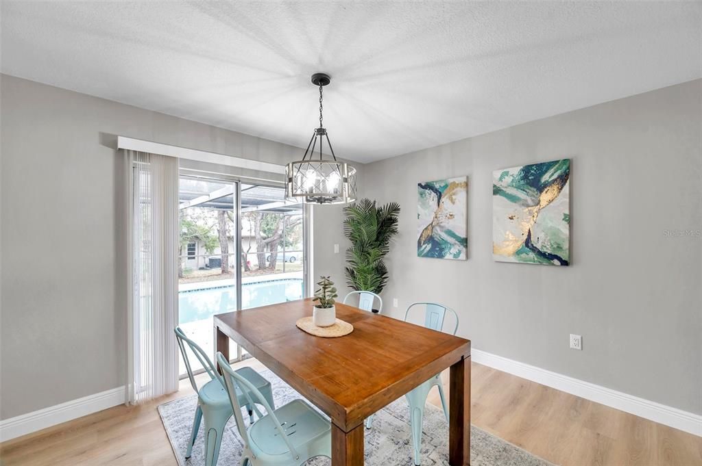 Bright dining room with sliding glass doors that open to the pool area, offering the perfect blend of indoor and outdoor living