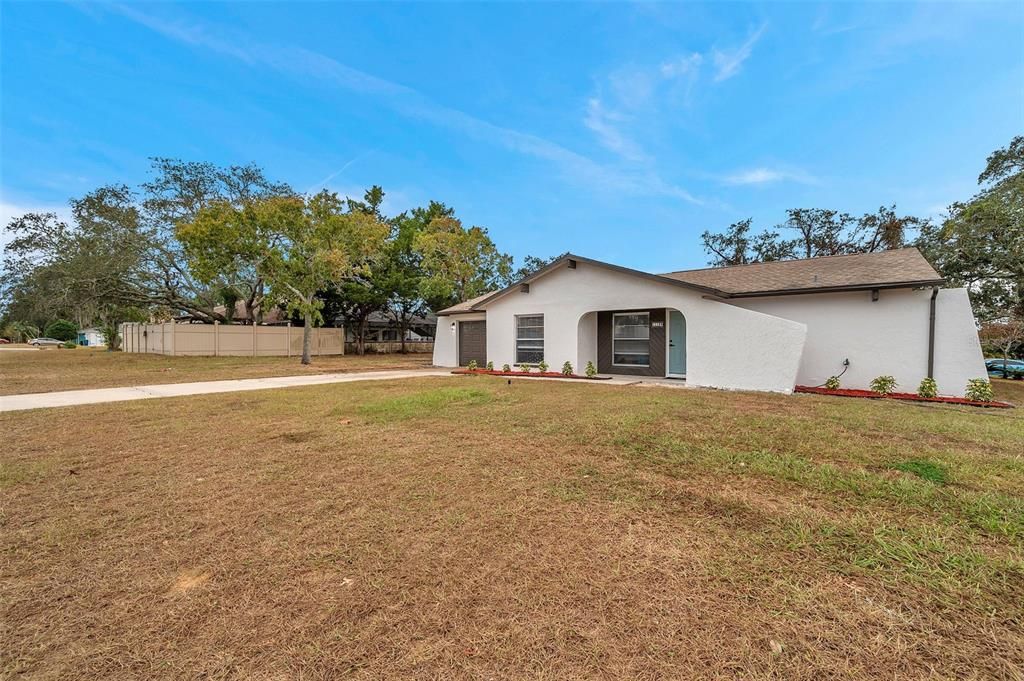 Expansive aerial views of the property, featuring mature shade trees that provide privacy and natural beauty while framing the home, spacious yard, and screened pool enclosure.