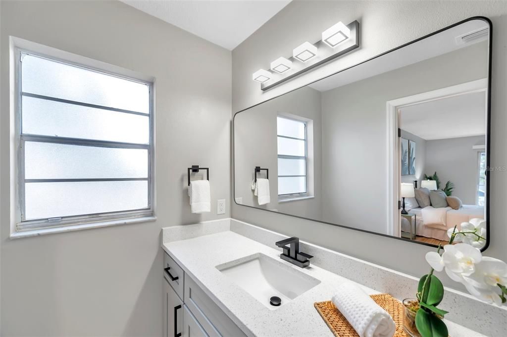 Another view of the newly remodeled primary bathroom showcasing a bright window, with the option for replacement or a credit provided at closing—customizable to your preferences!