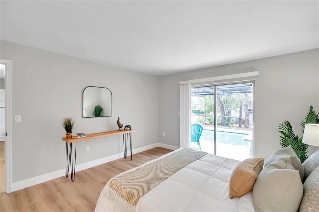 Spacious primary bedroom featuring sliding glass doors that open directly to the pool area—your private retreat with easy access to outdoor relaxation.