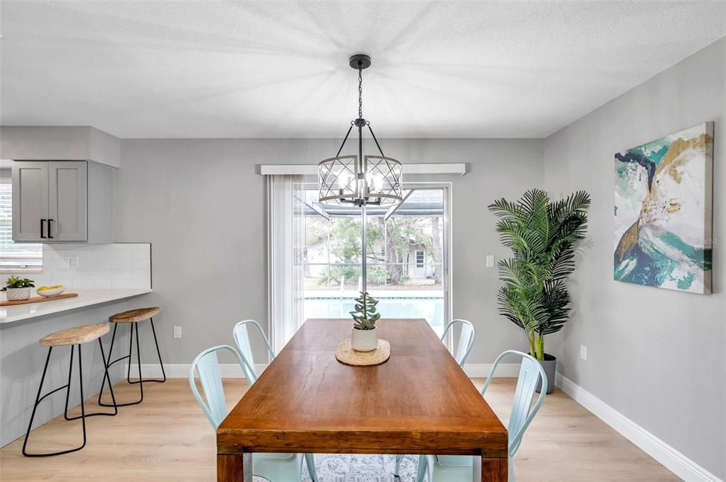 Bright dining room with sliding glass doors to the pool area and a convenient breakfast bar just off the dining room, creating a seamless flow for entertaining and everyday living.