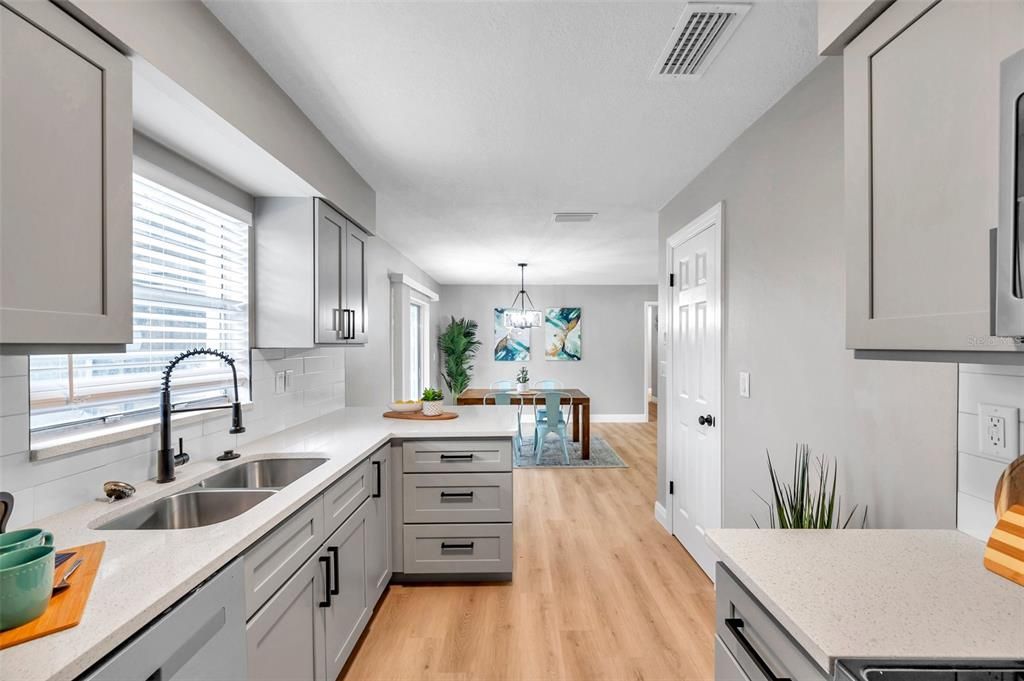 Charming kitchen view with a breakfast bar overlooking the workspace, seamlessly transitioning to the dining room beyond—perfect for gatherings and casual dining