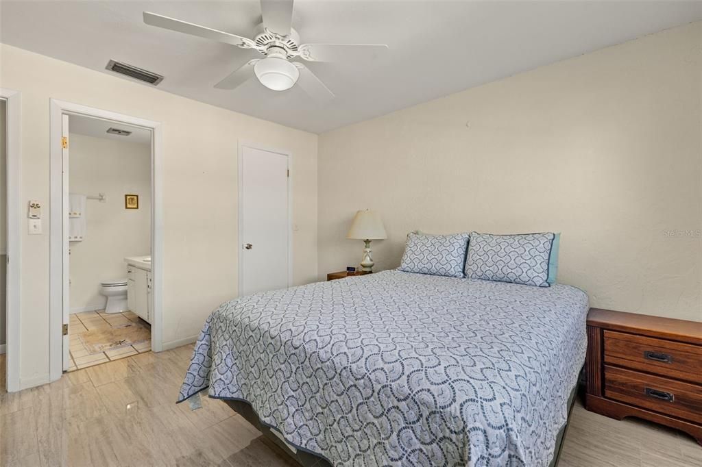 Bedroom featuring en-suite bathroom, ceiling fan