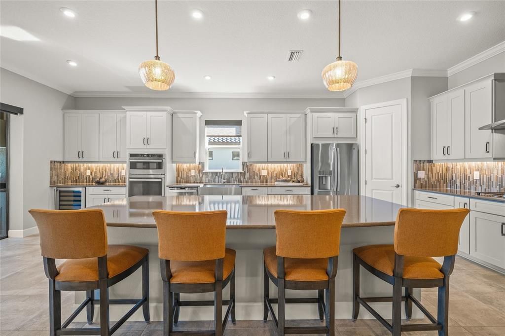 Custom Gourmet Kitchen with Soft Close Cabinets & Drawers, Oversized Island, Quartz Countertops, Range Hood, Gas Cooktop, Stainless Appliances, Farmhouse Sink, Wine Fridge, Wall Mounted Oven and Microwave, and eating space for a breakfast table if you so choose.