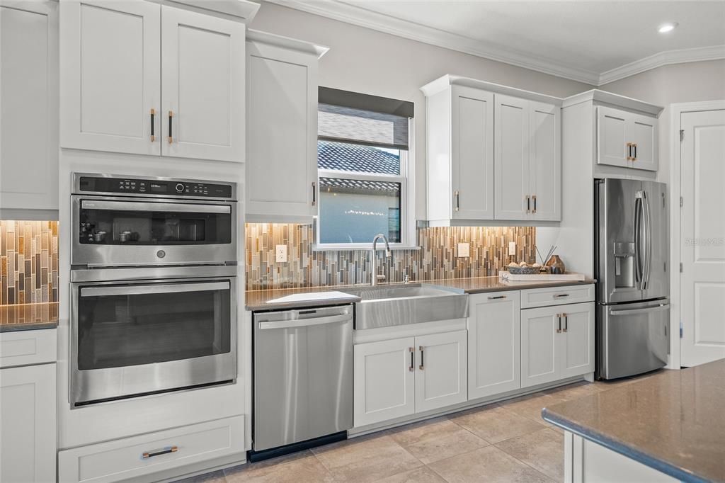 Custom Gourmet Kitchen with Soft Close Cabinets & Drawers, Oversized Island, Quartz Countertops, Range Hood, Gas Cooktop, Stainless Appliances, Farmhouse Sink, Wine Fridge, Wall Mounted Oven and Microwave, and eating space for a breakfast table if you so choose.