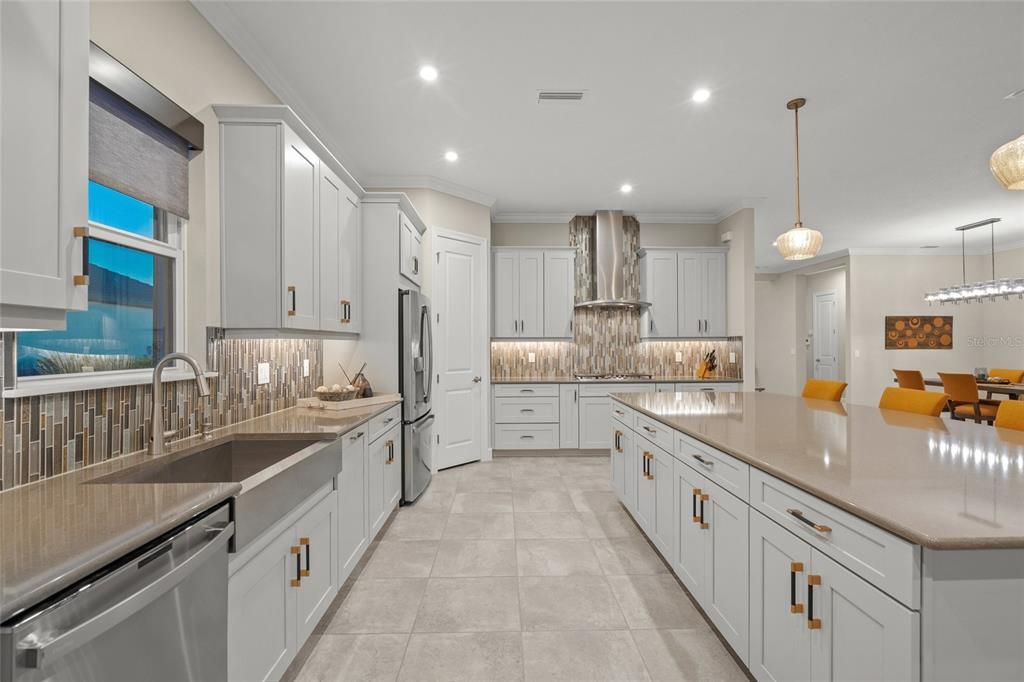 Custom Gourmet Kitchen with Soft Close Cabinets & Drawers, Oversized Island, Quartz Countertops, Range Hood, Gas Cooktop, Stainless Appliances, Farmhouse Sink, Wine Fridge, Wall Mounted Oven and Microwave, and eating space for a breakfast table if you so choose.