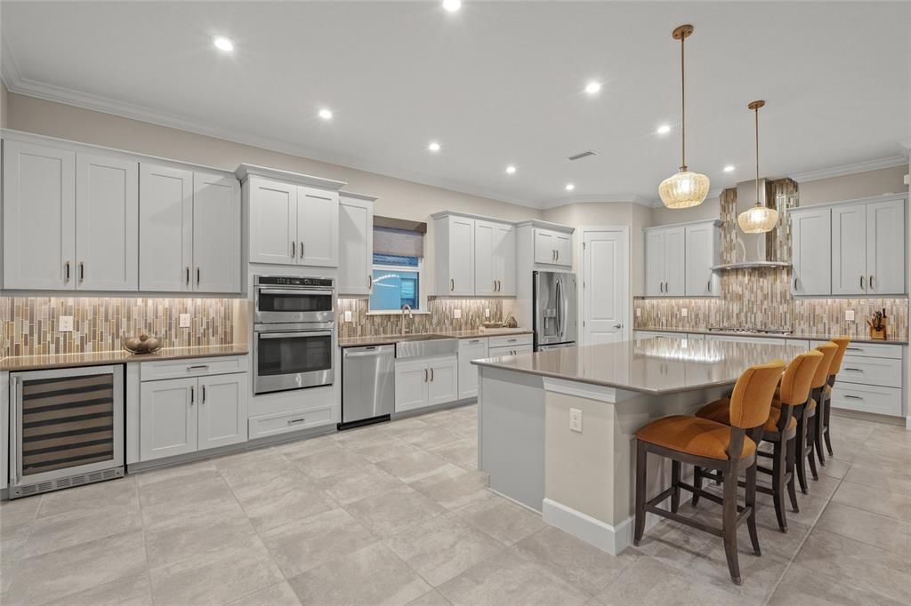 Custom Gourmet Kitchen with Soft Close Cabinets & Drawers, Oversized Island, Quartz Countertops, Range Hood, Gas Cooktop, Stainless Appliances, Farmhouse Sink, Wine Fridge, Wall Mounted Oven and Microwave, and eating space for a breakfast table if you so choose.