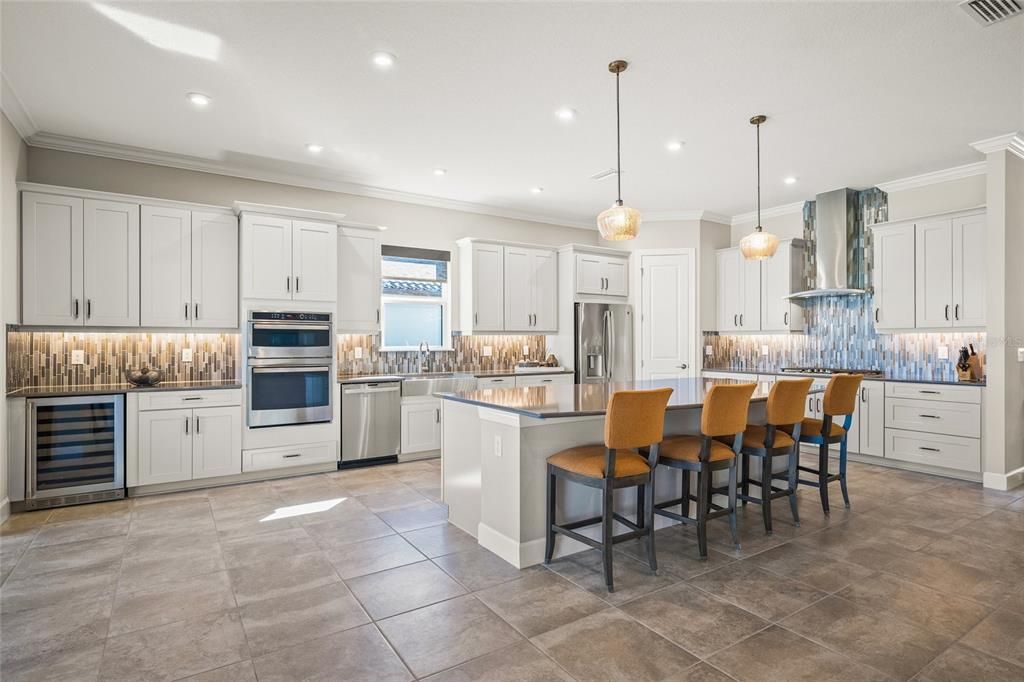 Custom Gourmet Kitchen with Soft Close Cabinets & Drawers, Oversized Island, Quartz Countertops, Range Hood, Gas Cooktop, Stainless Appliances, Farmhouse Sink, Wine Fridge, Wall Mounted Oven and Microwave, and eating space for a breakfast table if you so choose.