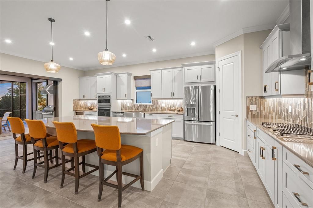 Custom Gourmet Kitchen with Soft Close Cabinets & Drawers, Oversized Island, Quartz Countertops, Range Hood, Gas Cooktop, Stainless Appliances, Farmhouse Sink, Wine Fridge, Wall Mounted Oven and Microwave, and eating space for a breakfast table if you so choose.