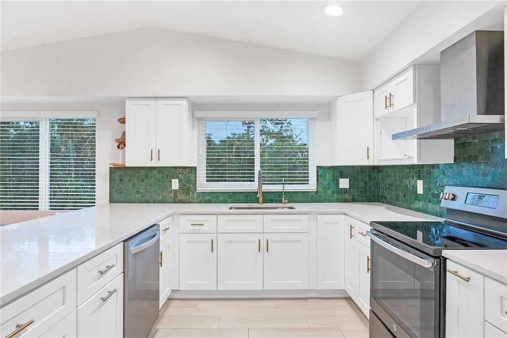 Emerald tile backsplash clashes perfectly with the gold accents.