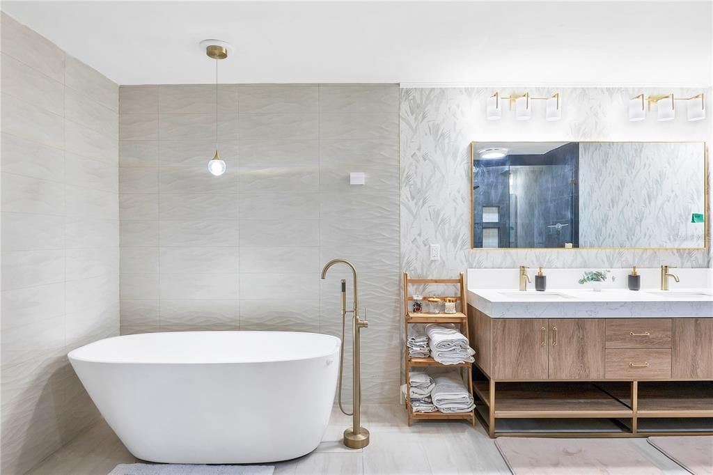 Owners ensuite bathroom featuring a freestanding tub with a modern tiled backsplash.