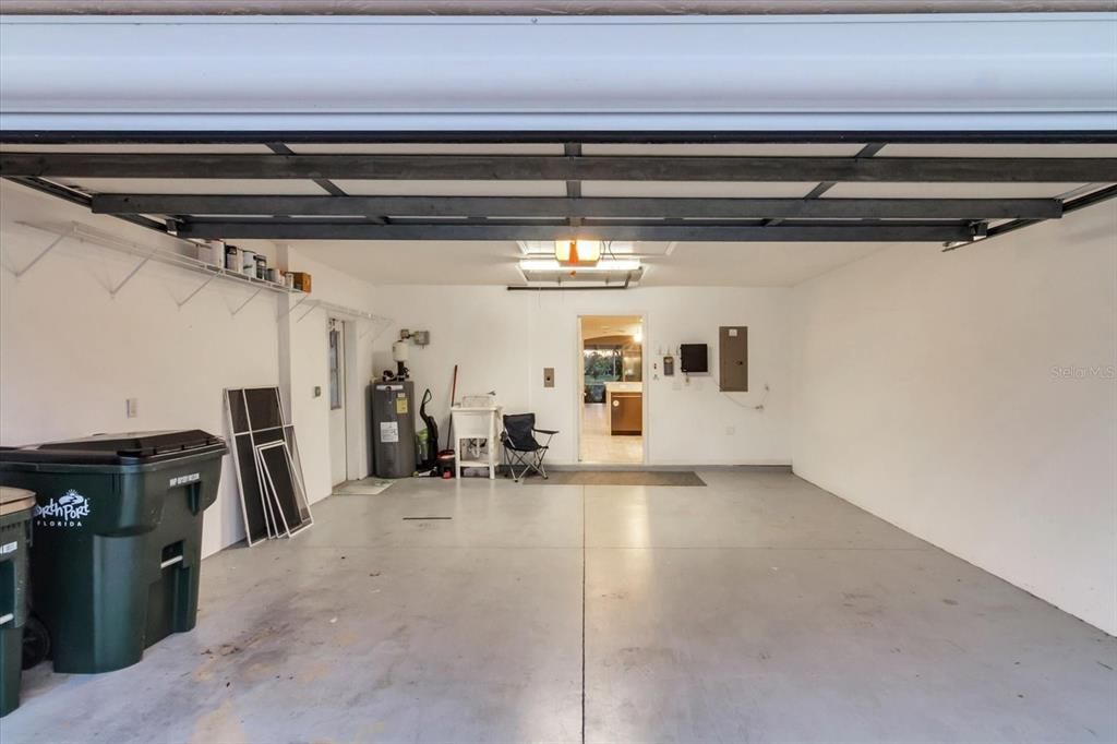 Garage with epoxy floor and side door entry. A motorized screen is attached to the front of the garage entry.