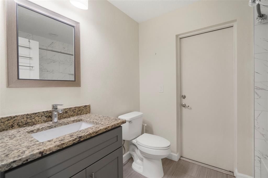 Guest bathroom with access door to backyard.