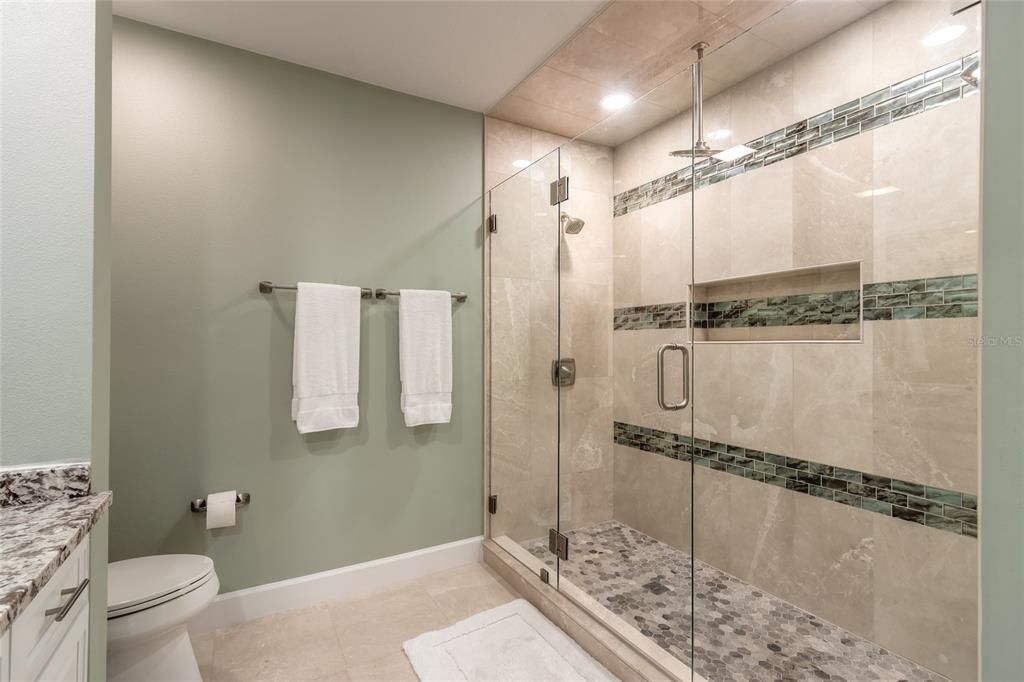 Primary bedroom's bathroom boast an enlarged shower with 2 shower heads & a rain shower head and beautiful accent tile