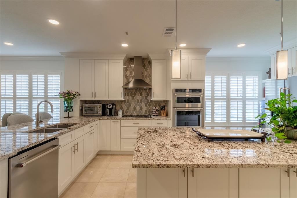 Open and spacious custom kitchen granite counter tops and gorgeous backsplash