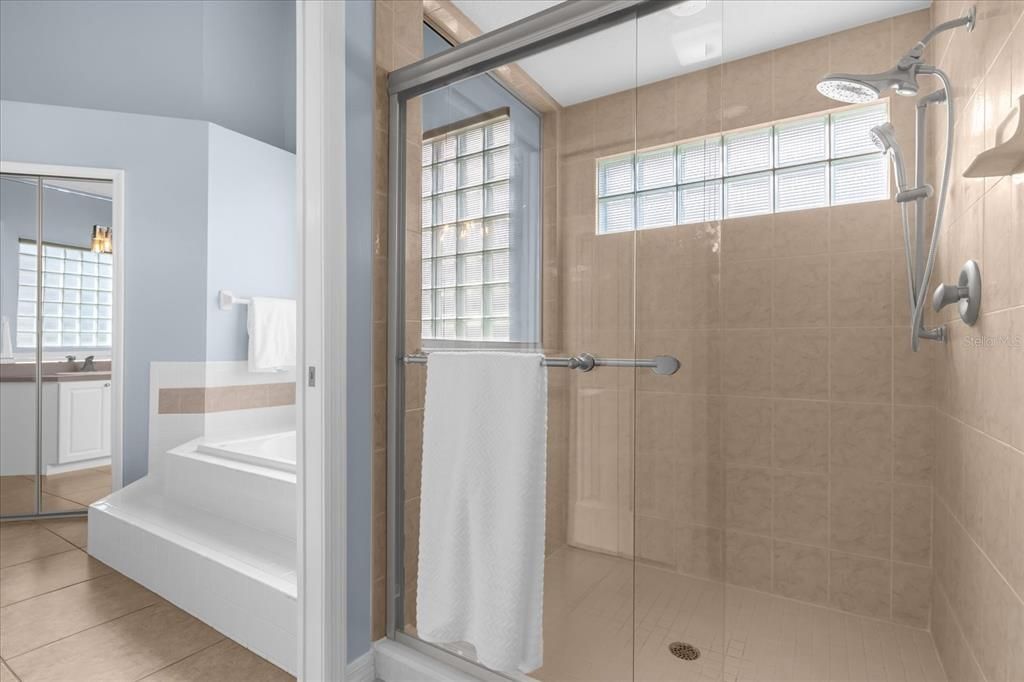 Primary Bathroom with large walk in shower with glass sliding doors