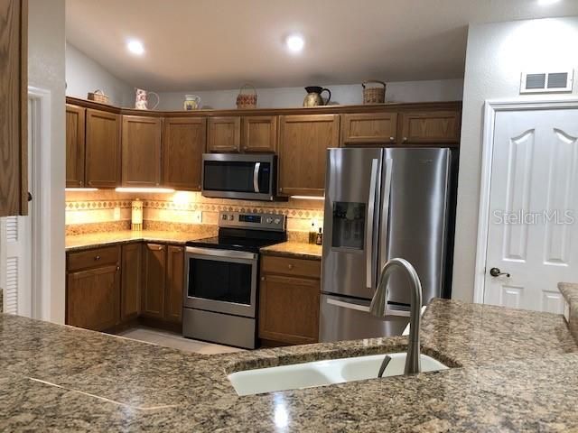 granite and custom backsplash with lighting