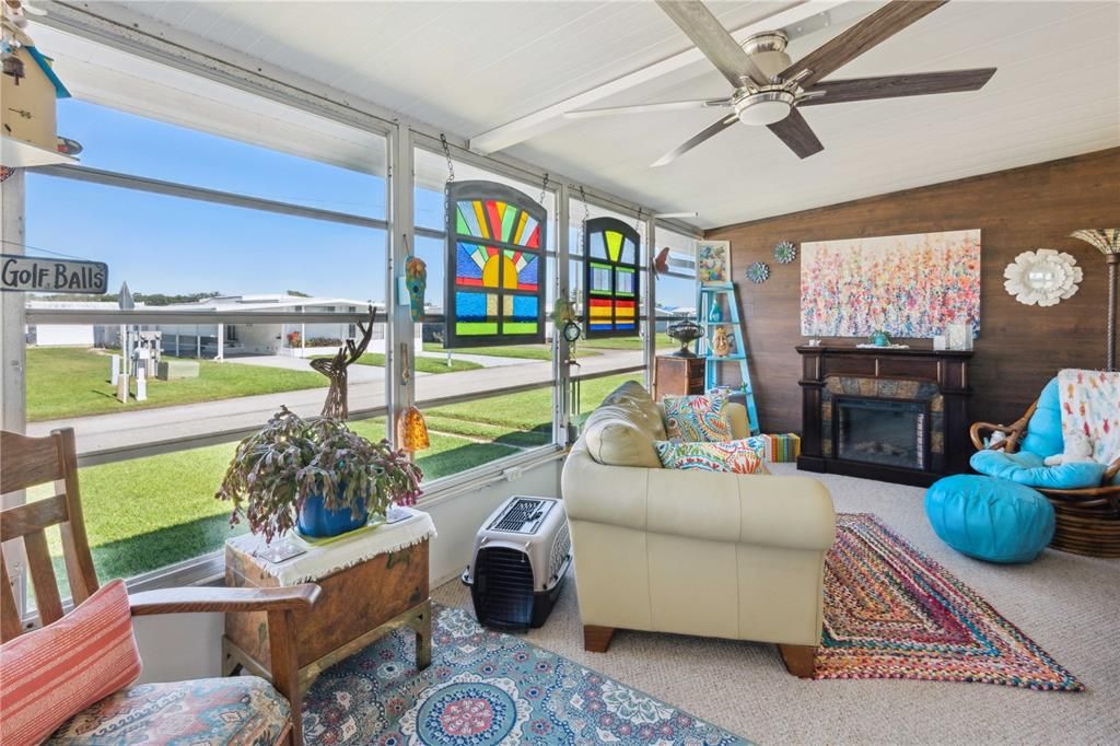 Florida room is off the carport with custom accent wall, new ceiling fan, and Berber carpeting.