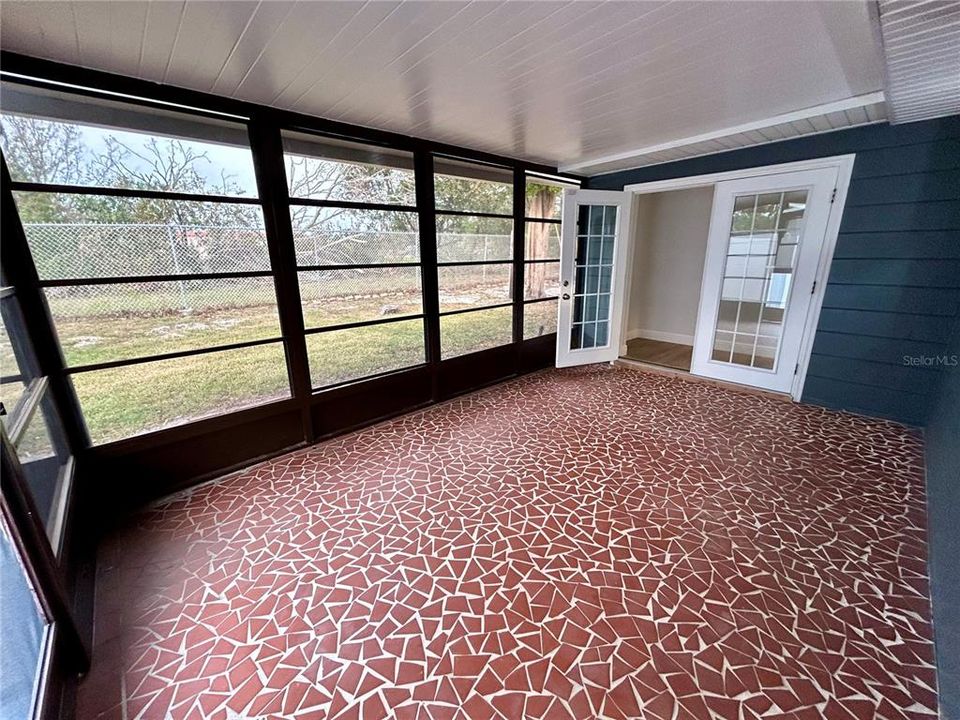 Screened-in porch with view of back yard