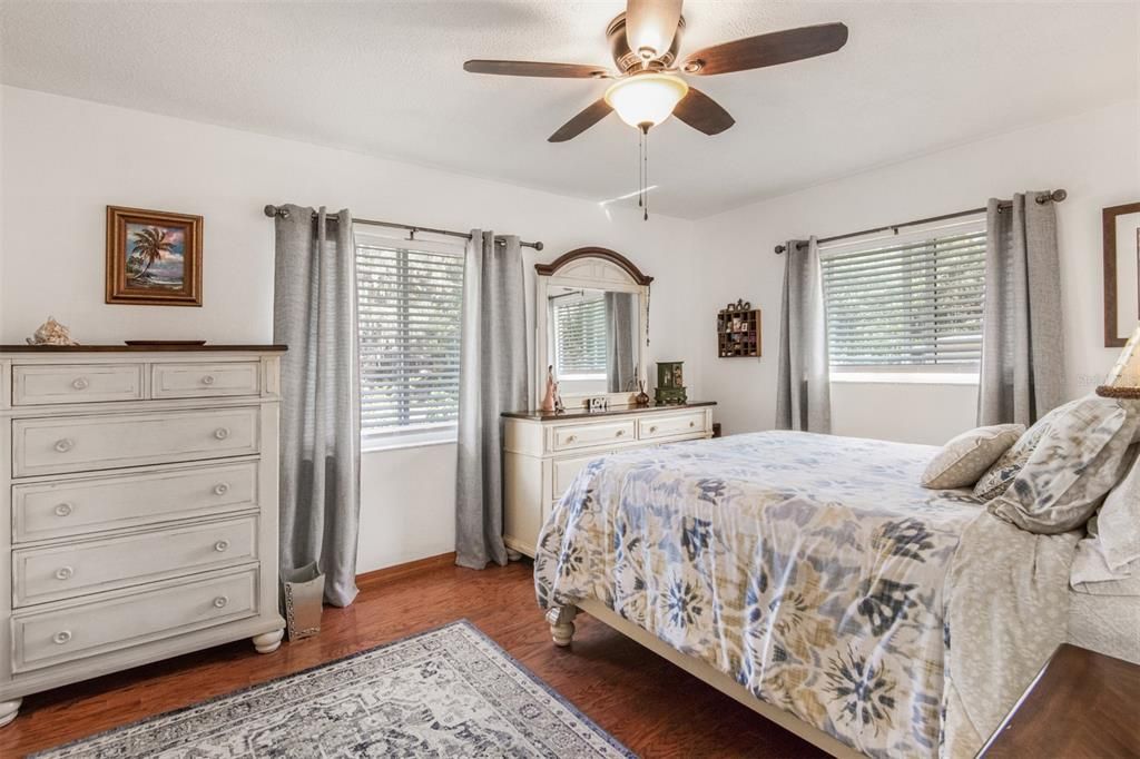 Pretty Guest Or Primary Bedroom With Hardwood Floors