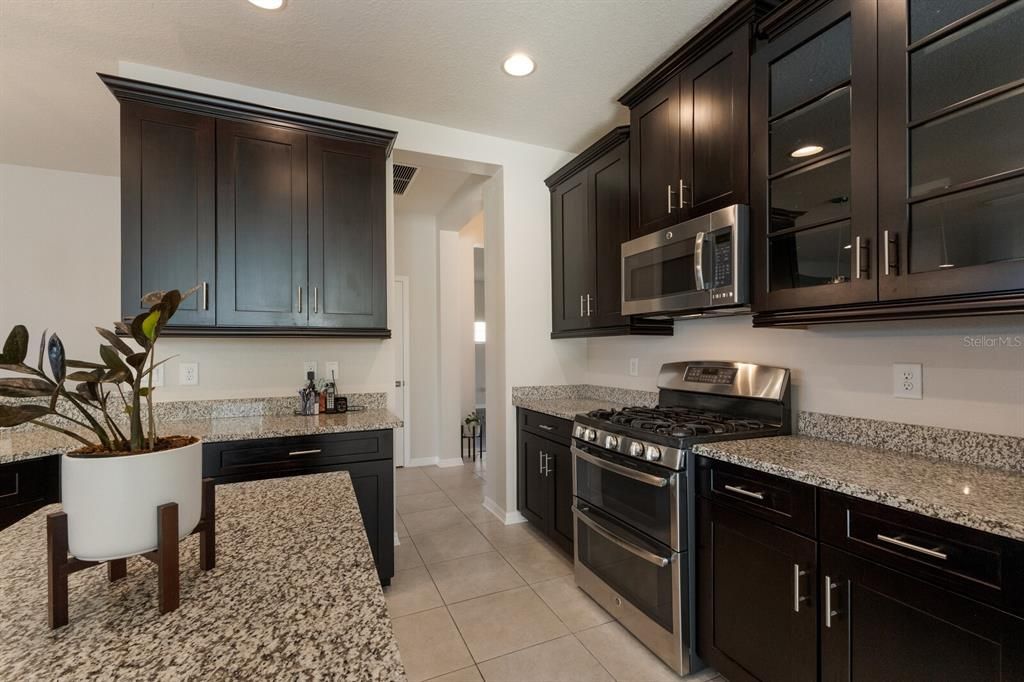 Lovely kitchen with rich maple wood cabinets, gas range and center island.