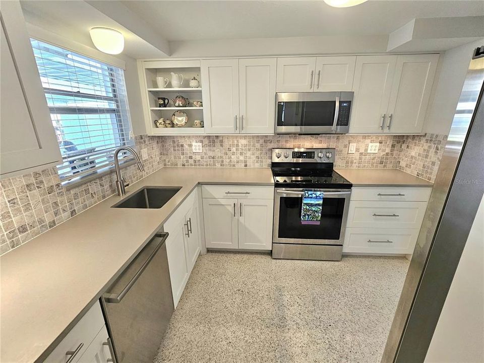 Solid surface counters with deep stainless sink with complimentary backsplash