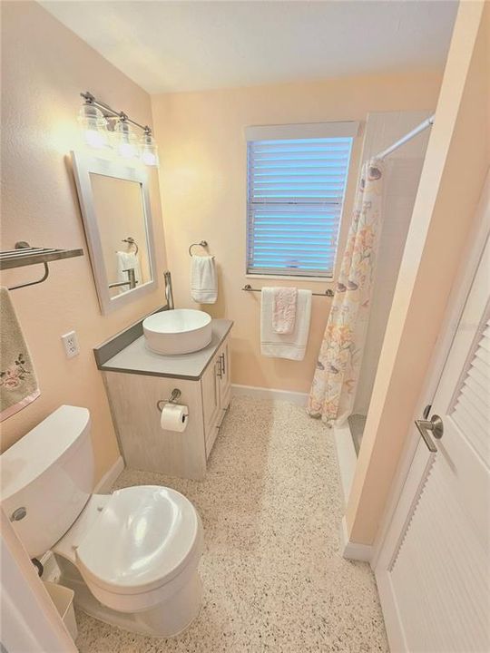 Primary bathroom with solid surface counter and a shower with no tub