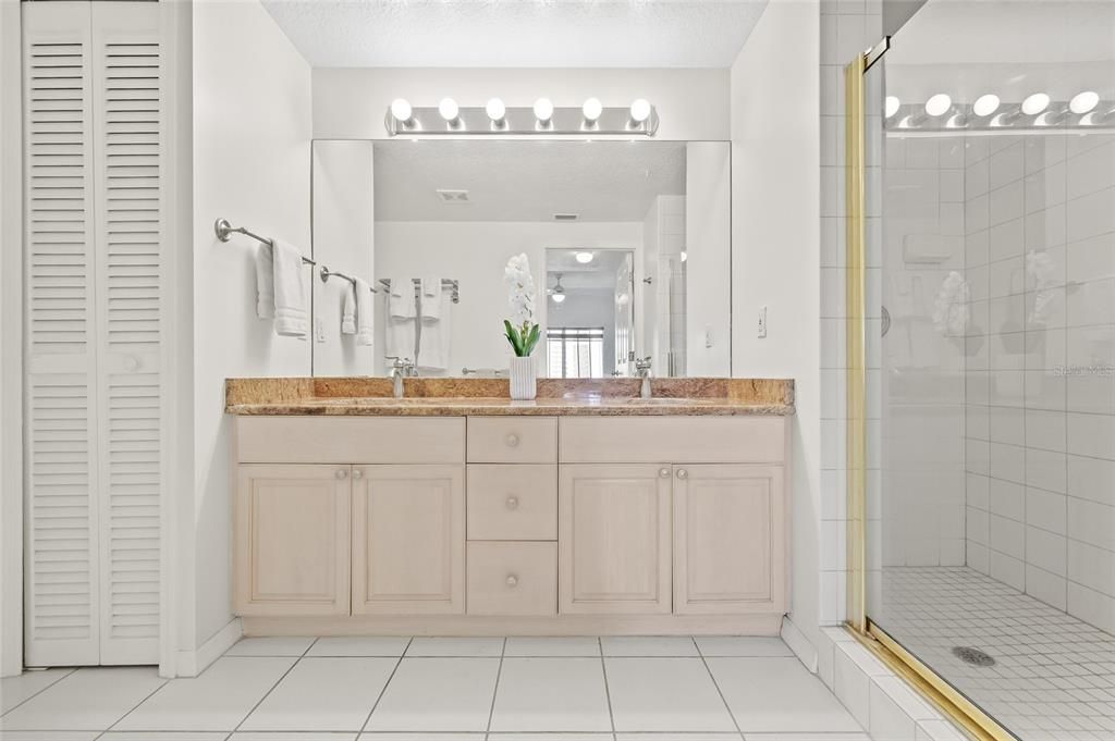 Primary Bathroom with dual sinks, step in shower and granite counter.