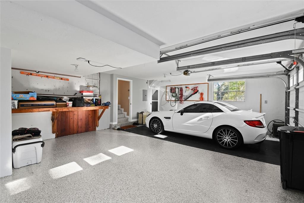 Interior of 2-car garage with an epoxy floor and the entrance to the basement