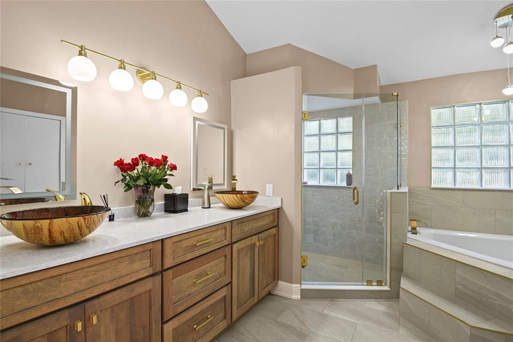 Massive spa-like primary bathroom with sandstone flooring