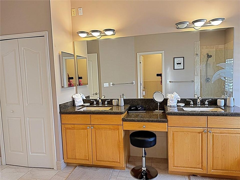 Primary bathroom ensuite with dual vanities and make seating.