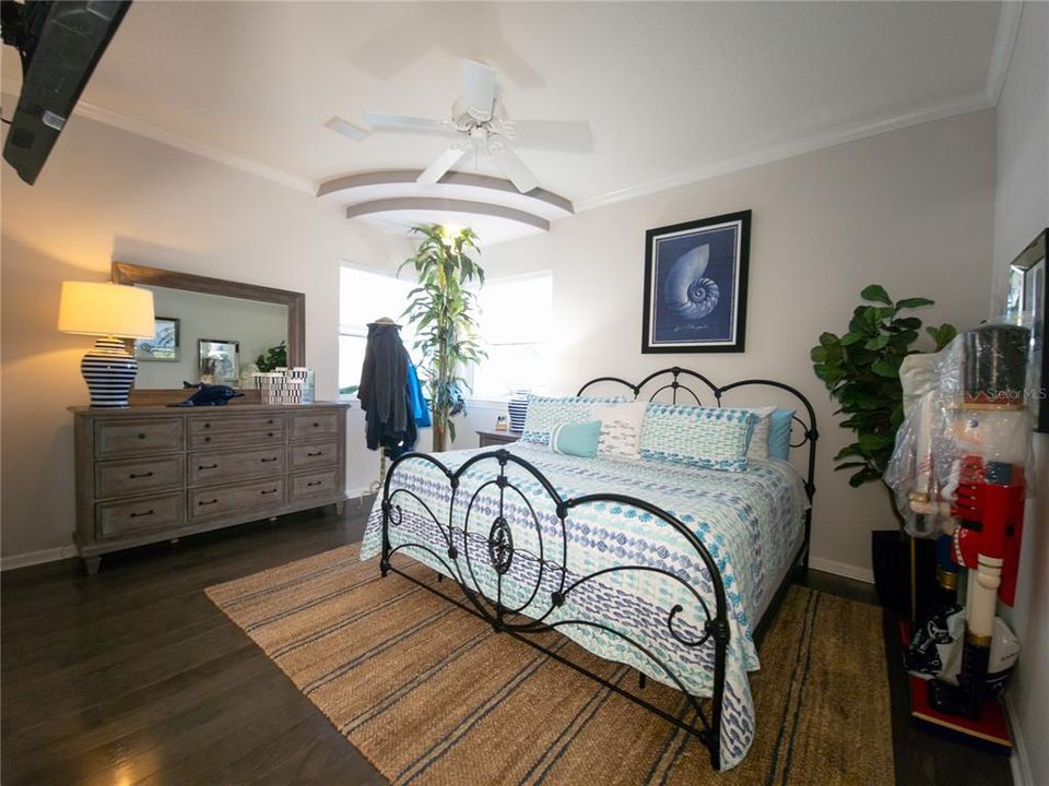 Guest bedroom with wood flooring