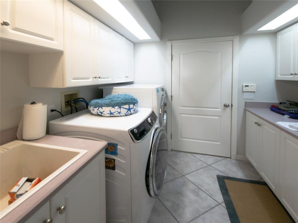 Utility room with indirect lighting and plenty of cabinets, set tub