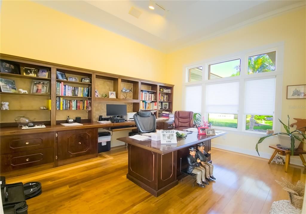 Office with wood flooring and built-in