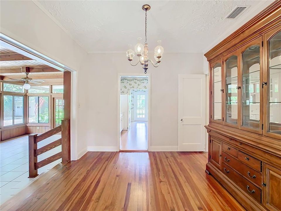 Dining room with wood floors located next to the family room and kitchen.