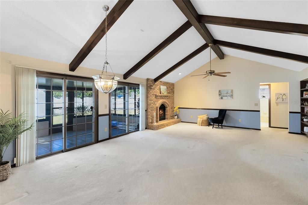 Large dining and living area with vaulted ceilings, wood beams, and Anderson sliders