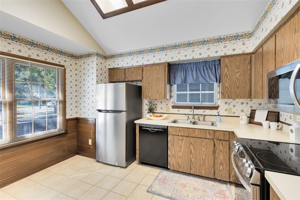 Kitchen with wood paneling, updated appliances, Anderson windows