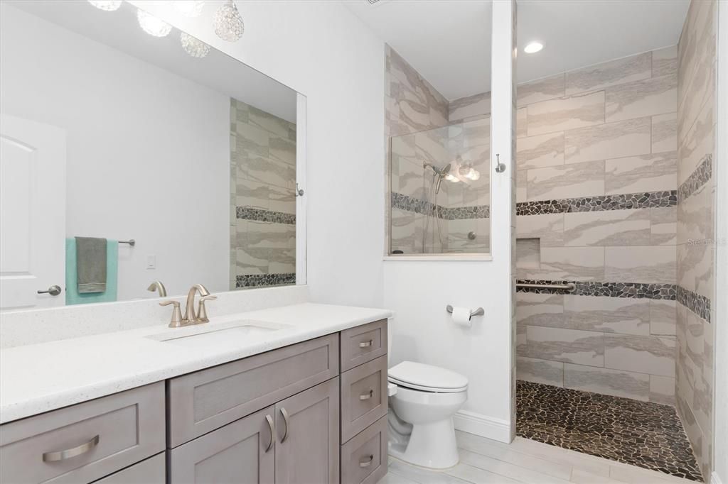 Accessible ensuite bath with an extended vanity with extracounter space and storage coupled with the roll-in, accessible tiled shower invite you into your private sanctuary.