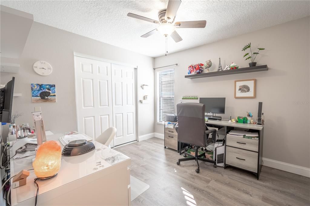 Bedroom 2 features durable vinyl flooring, a built-in closet, neutral tones and a ceiling fan with light kit.