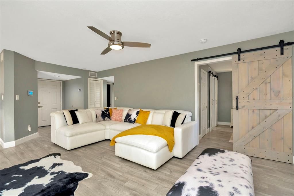 Living room and barn door to primary bedroom