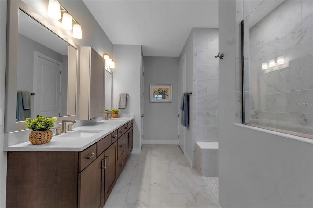 Primary bath with super shower, bench. Dual vanities with custom center "medicine" cabinet