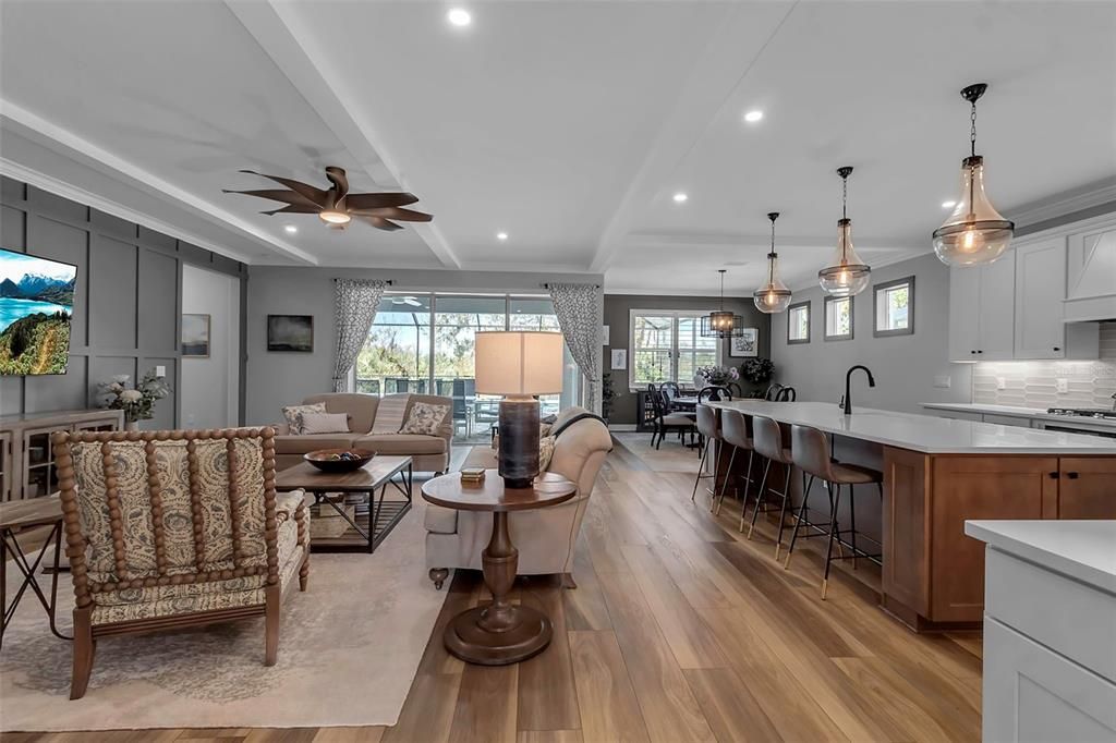 Gathering room overview- Faux beams were added to give ceiling dimension; designer wall; two tone kitchen and each and every light fixture and fan was carefully chosen