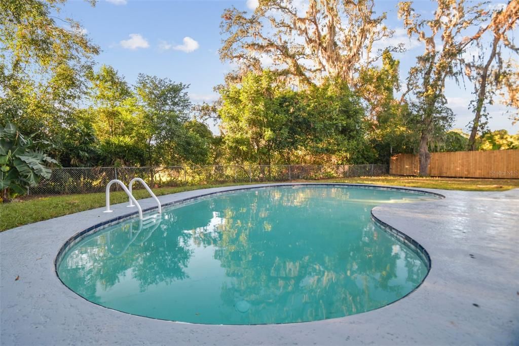 Fenced in backyard with lots of surrounding trees