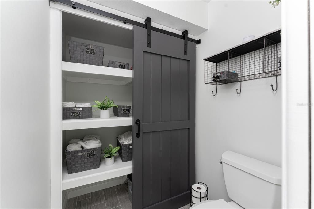 Water Closet has Plenty of Storage Behind Barn Doors