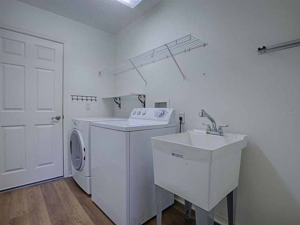 LAUNDRY ROOM HAS A TUB SINK AND SHELVING