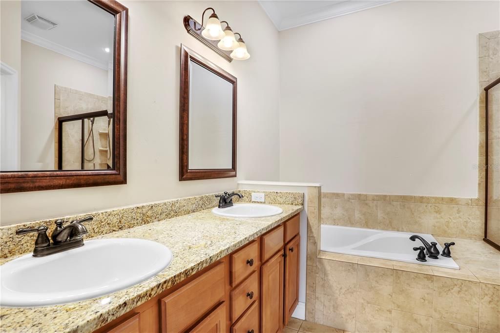 Primary suite's dual vanity w/ granite counter tops