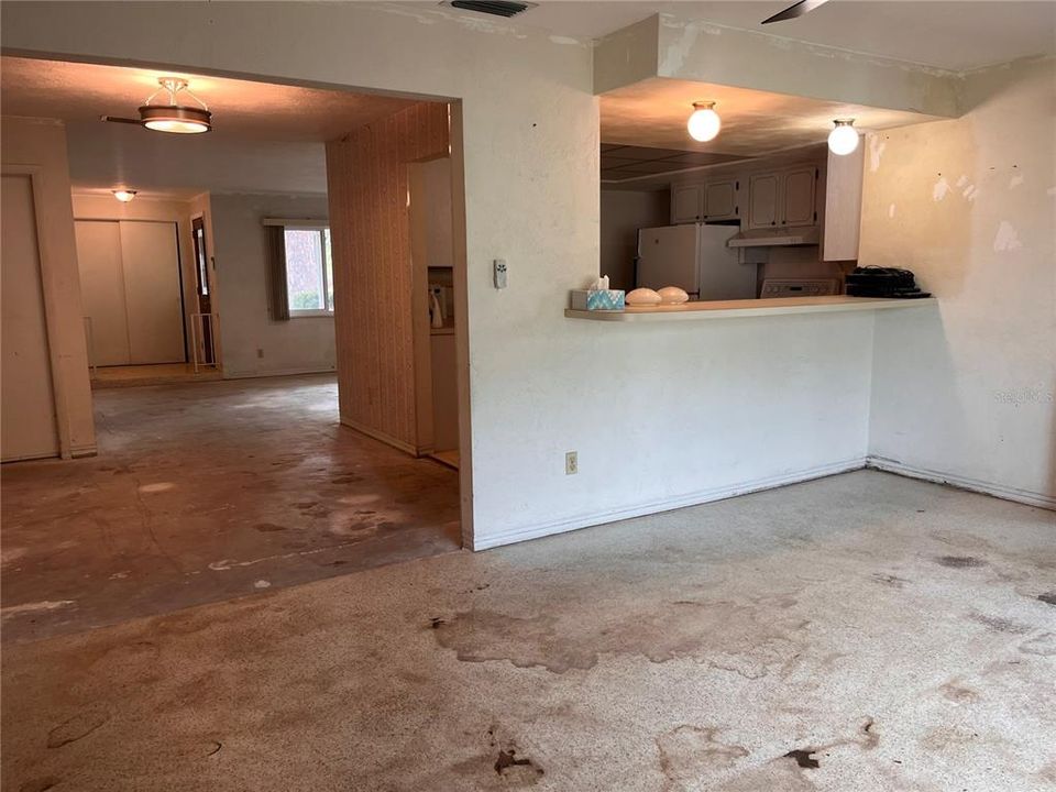 Family room with view of dining room on left (terrazzo floor with glue residue from carpet)